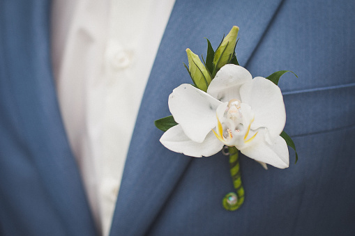 Elegant wedding boutonniere on the groom's suit.