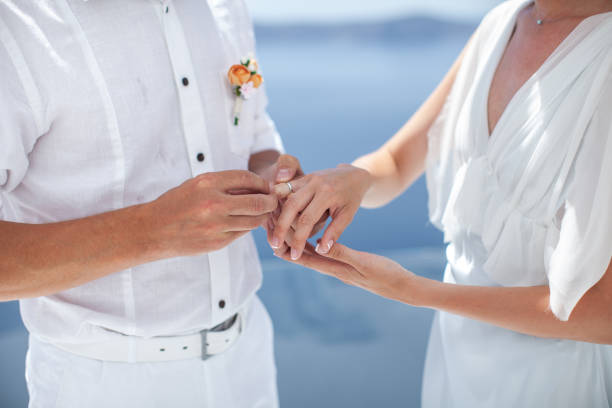 istock Bride and groom exchange rings at the wedding ceremony 1425114105