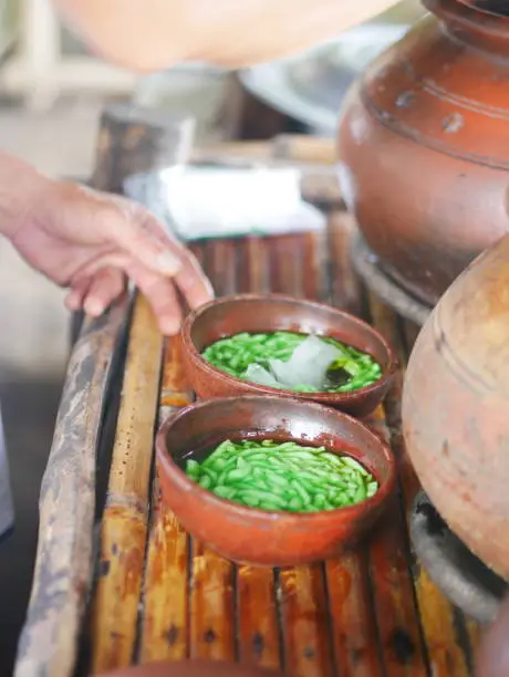 Photo of An Indonesian dewet/cendol seller prepares the buyer's order at the afternoon.