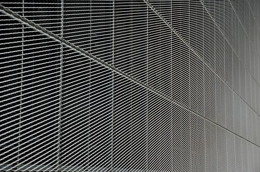 steel cladding of a building with a expanded metal lattice structure. galvanized gray nets protect the industrial building. Blue sky in contrast to a silver background, wall, expanded, lattice, ventilation, panelling