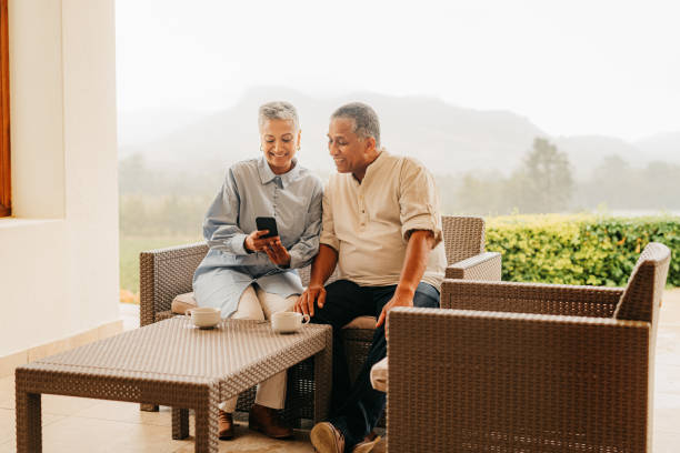 istock Senior couple, phone on a home patio using mobile technology outdoors together. Internet, digital and social media content scroll of a elderly man and woman from Pakistan with a happy smile in winter 1425119093
