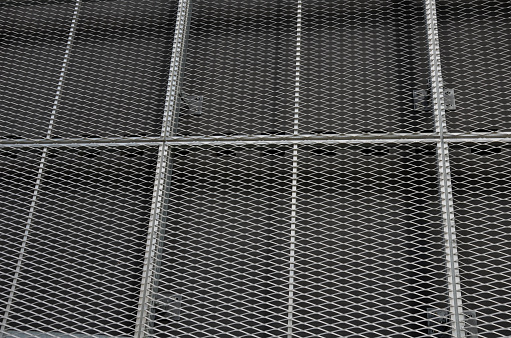 steel cladding of a building with a expanded metal lattice structure. galvanized gray nets protect the industrial building. Blue sky in contrast to a silver background, wall, expanded, lattice, ventilation, panelling
