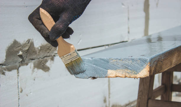 istock A hand with a brush that paints a tree gray. 1425121717