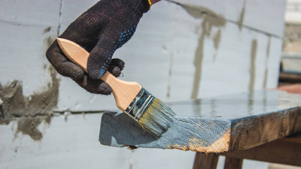istock A hand with a brush that paints a tree gray. 1425121724