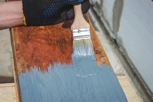 istock A hand with a brush that paints a tree gray. 1425121728