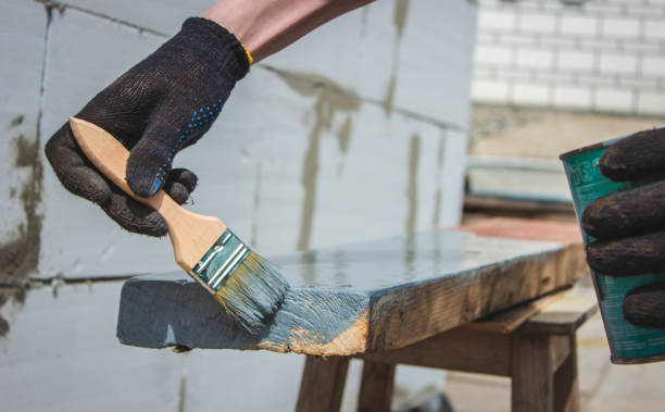 istock A hand with a brush that paints a tree gray. 1425121736