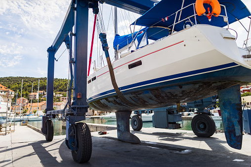Sailboat service, a small yacht stands on repairs supports in a dry dock