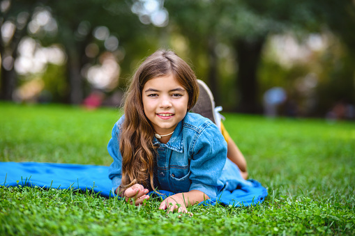 Cute girl lying on the grass in a city park