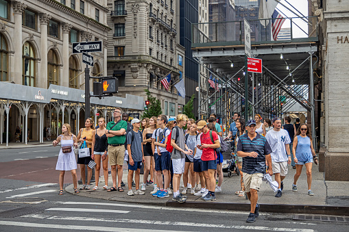 Times Square, Manhattan, New York, NY, USA - July 17th 2022: Large group of people waiting in front of a zebra crossing