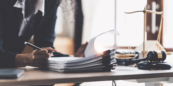 Abogada mujer de negocios que trabaja o lee un libro de leyes en el lugar de trabajo de la oficina para el concepto de abogado consultor photo