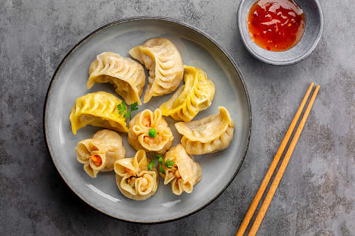 Assorted Chinese dim sum dumplings stuffed with meat and shrimps and sweet sauces. Jiao zi, shao mai, niu rou jiao with saffron and beef filling.  Asian food.