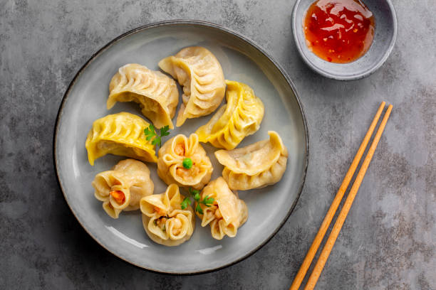Assorted Chinese dim sum dumplings stuffed with meat and shrimps and sweet sauces. Jiao zi, shao mai, niu rou jiao with saffron and beef filling.  Asian food. stock photo
