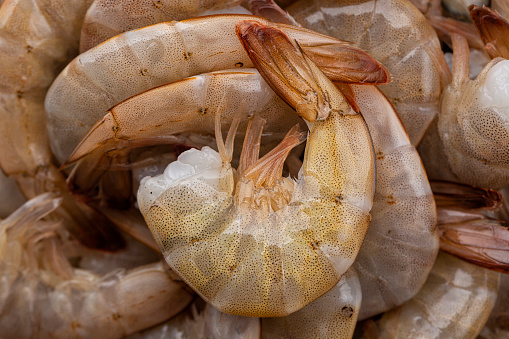 Background. Close-up of Raw fresh headless shrimp tails or prawns directly above, uncooked jumbo seafood.