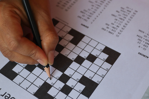 Pencil and glasses on the paper with solved number crossword puzzle