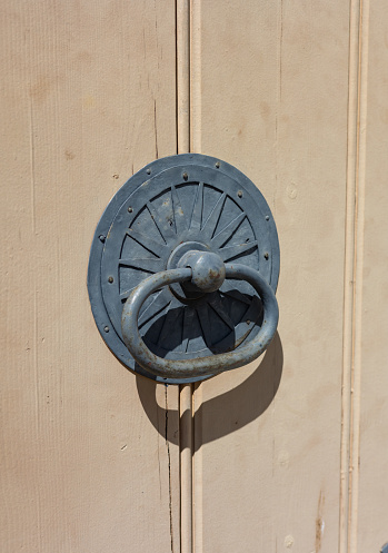 Traditional brass door knocker on a red door in Meknes, Morocco.