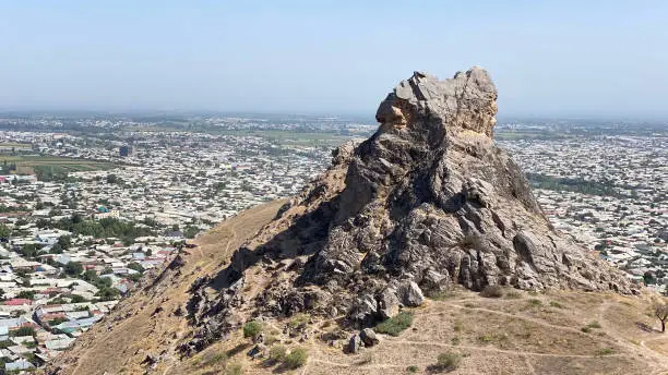 The rocky peak of the sacred mountain Sulaiman-Too. The city of Osh from a bird's eye view. View of amazing mountains. Beautiful nature of Kyrgyzstan.