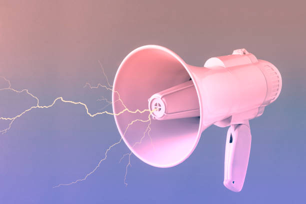 istock Vibrant pink megaphone with thunderbolt against purple-brown background. Minimal abstract retro futuristic concept of hurtful words, hate or free speech. 3D illustration. Vaporwave creative card. 1425136325