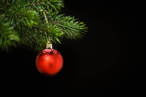 A close-up of a golden Christmas bauble illuminated by the soft glow of holiday lights in the background. The warm tones and festive ambiance evoke the magic of Berlin's Christmas market