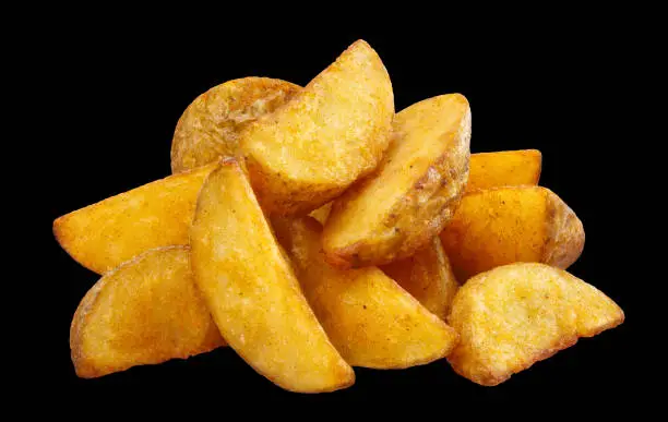 Delicious fried potato wedges, isolated on black background