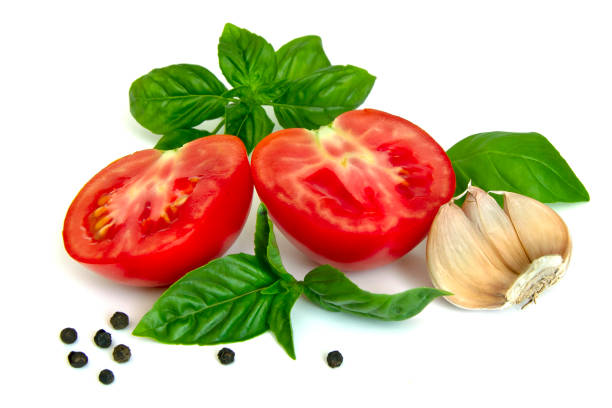 Slices of tomatoes, basil, garlic, black pepper isolated on a white background