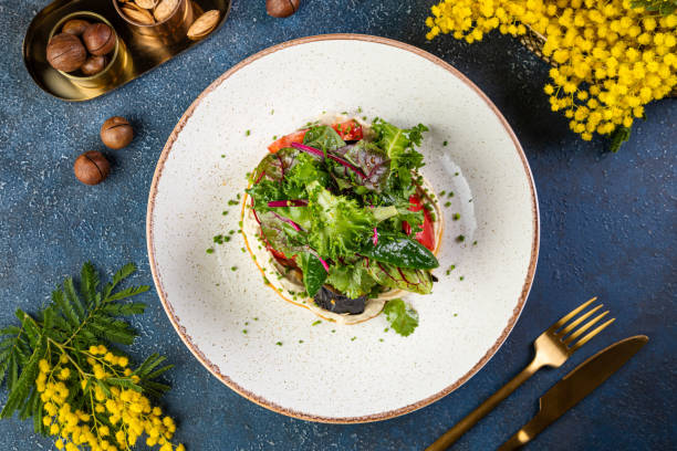 istock Fresh red tomatoes on dark stone table with Vegetables and herbs plate mix snack 1425136984