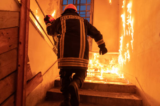 istock Brave Fireman going upstairs to save and rescue people in a Burning Building. Open fire and flame. 1425137724