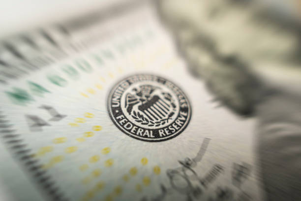 focus selettivo sull'emblema della federal reserve statunitense sulla banconota da cento dollari mentre la fed considera l'aumento dei tassi di interesse, l'economia e il controllo dell'inflazione dell'organizzazione nazionale. - interest rate loan finance government foto e immagini stock