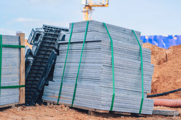 istock Industrial building cement pressed materials. Concrete block cement brick. Finished products on pallets compactly stacked wooden frame placed on construction site house, rope tape packed open air sky 1425138300