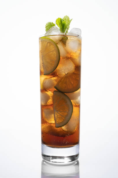 Cuba libre highball cocktail of cola and rum, and in many recipes lime juice on ice Cuba libre cocktail in tall glass isolated on white background. Rum and Coke, or the Cuba libre, is a highball cocktail consisting of cola, rum, and in many recipes lime juice on ice cuba libre stock pictures, royalty-free photos & images