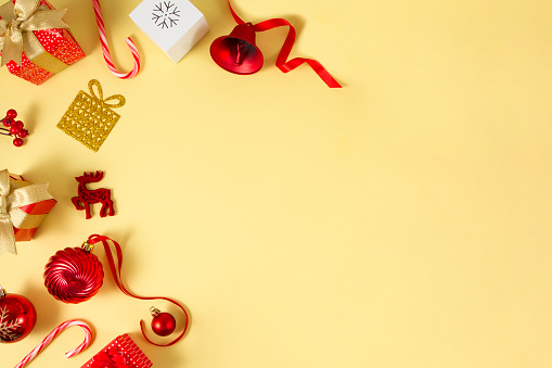 Christmas ornaments, gifts and candy canes on yellow background