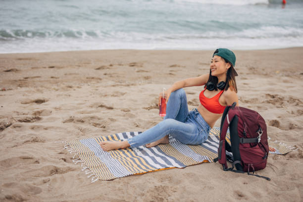 istock Young Chinese woman sitting on a beach relaxing 1425145526