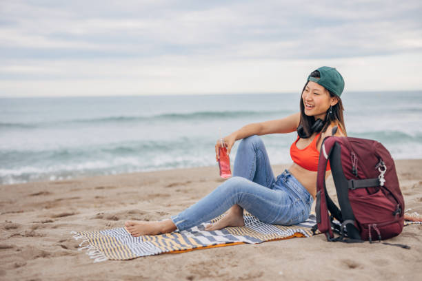 istock Young Chinese woman sitting on a beach relaxing 1425145575