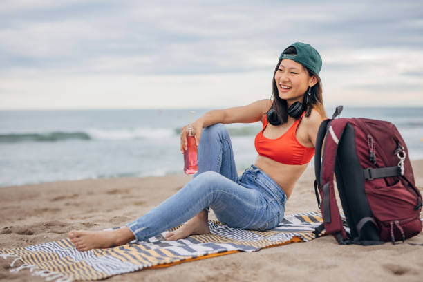 istock Young Chinese woman sitting on a beach relaxing 1425145590