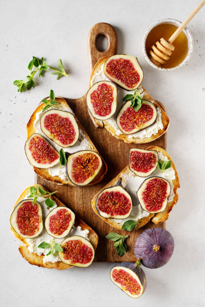 istock Fig bruschetta, bread and cream cheese and fruit on white background 1425145995