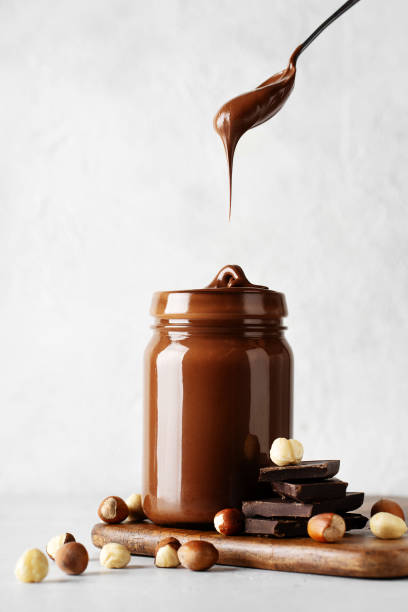 istock Chocolate paste in jar with nuts on cut wooden board 1425146077
