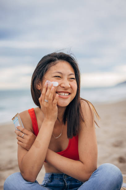 istock Young Chinese woman put lotion on face at a beach 1425146290