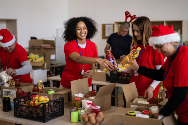 Group of multi-ethnic volunteers working in charitable foundation, packing donation boxes stock photo