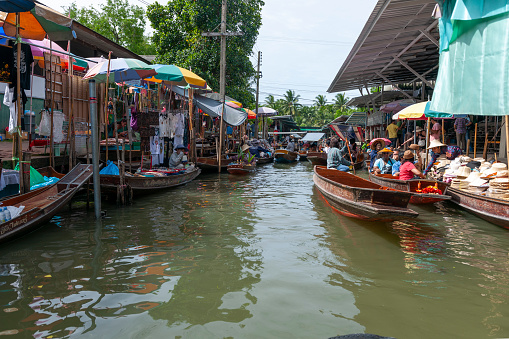 market vendors at the Damnoen Saduak floating market. The Damnoen Saduak floating market is a well-known travel destination for tourists visiting Thailand.