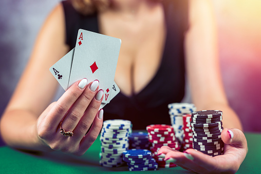 young woman in a black dress wins a game of blackjack and is happy with all the chips after playing poker. gambling concept. all in