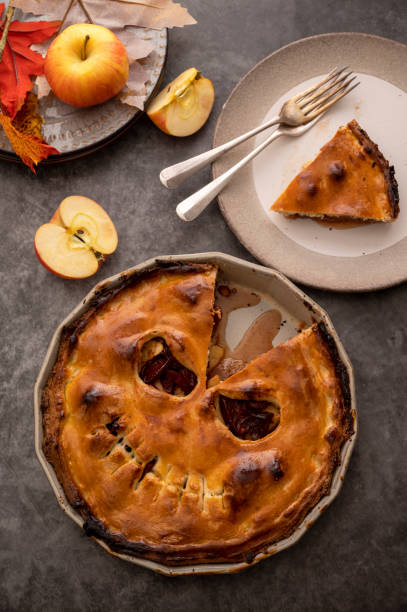 istock Halloween pie with funny pumpkin face carved on pie, top view. Autumn baking 1425151854