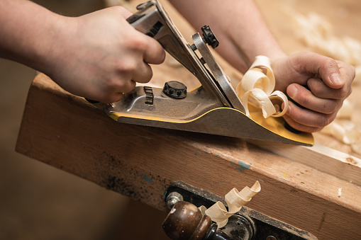 Close-up photo of male hands, planers at work, carpentry workshop