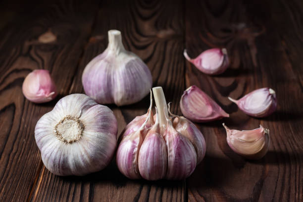 istock Garlic bulb on wooden background. Close up 1425158083