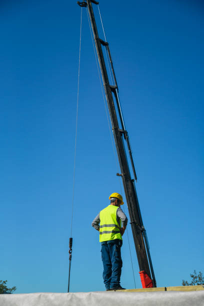 istock Construction worker standing on a wooden house construction site 1425158439