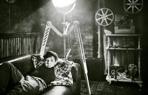 istock Tired Boy In Old-fashion Clothes Is Lying Down on Back On a Sofa 1425158453