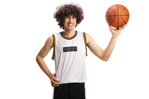 Basketball player holding a ball and smiling isolated on white background