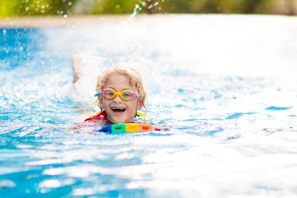 istock Child learning to swim. Kids in swimming pool. 1425162013