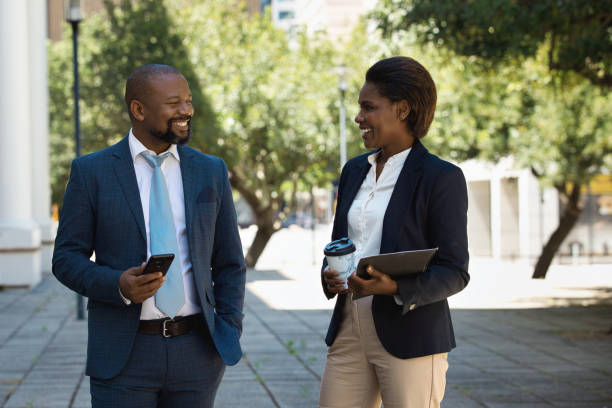 istock Two colleagues walking together and talking 1425163744