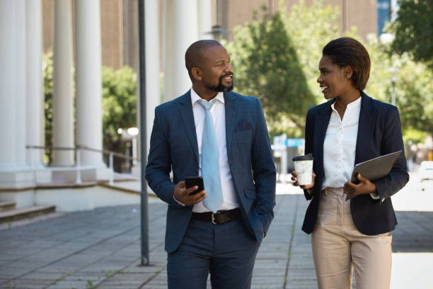 istock Two colleagues walking together and talking 1425163757