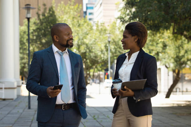 istock Two colleagues walking together and talking 1425163873