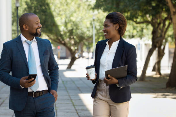 istock Two colleagues walking together and talking 1425163875